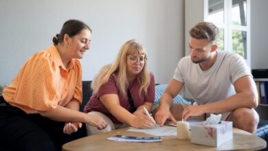 Zusammen Zuhause schaffen | Vermietender, Mieterin und Ehrenamtliche am Tisch bei Mietvertragsunterzeichnung
